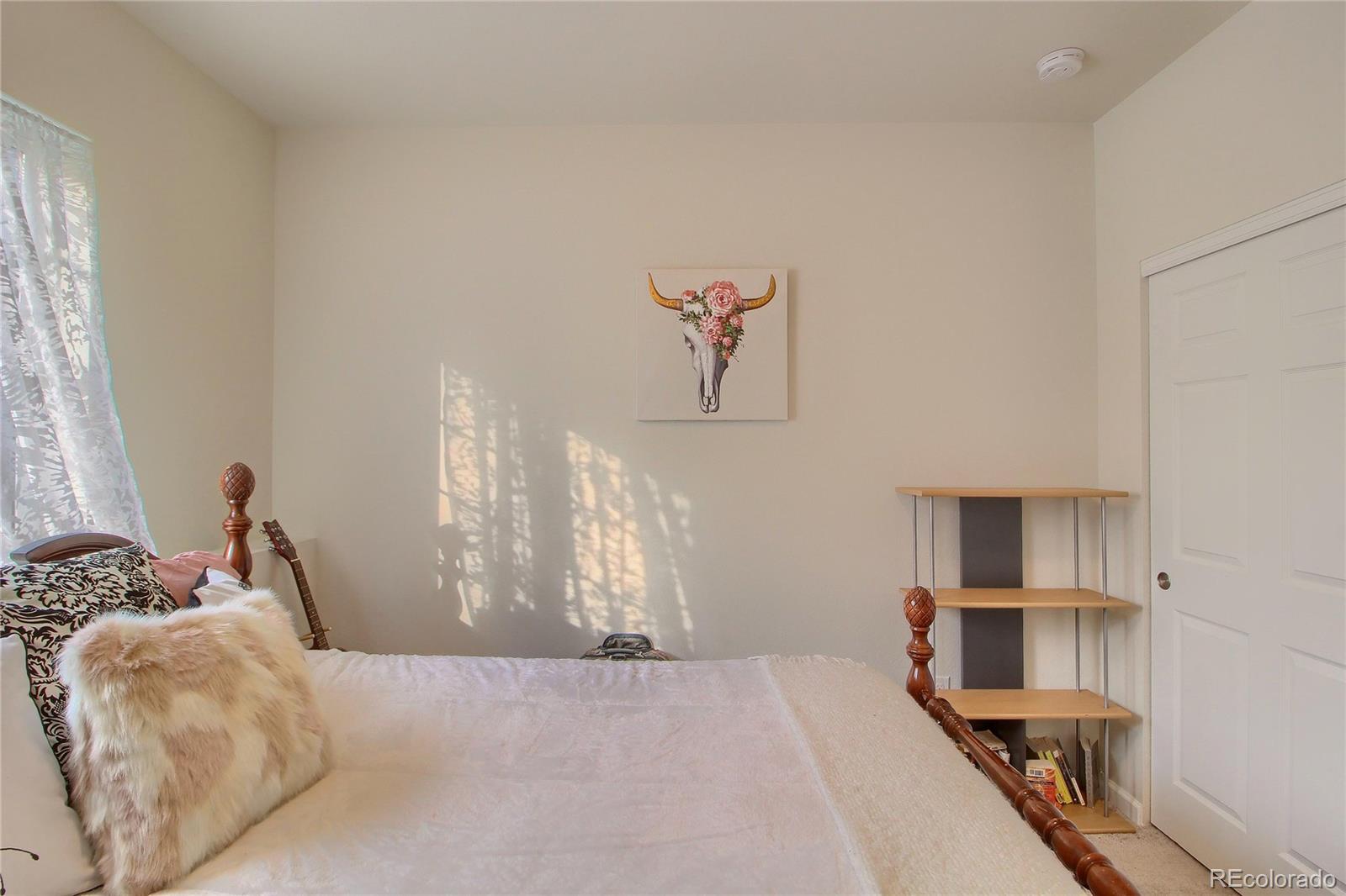 1335 South Chambers Road, Unit 101 Aurora, CO 80017 - Photo 29 of 40 a bedroom with a bed and a chandelier