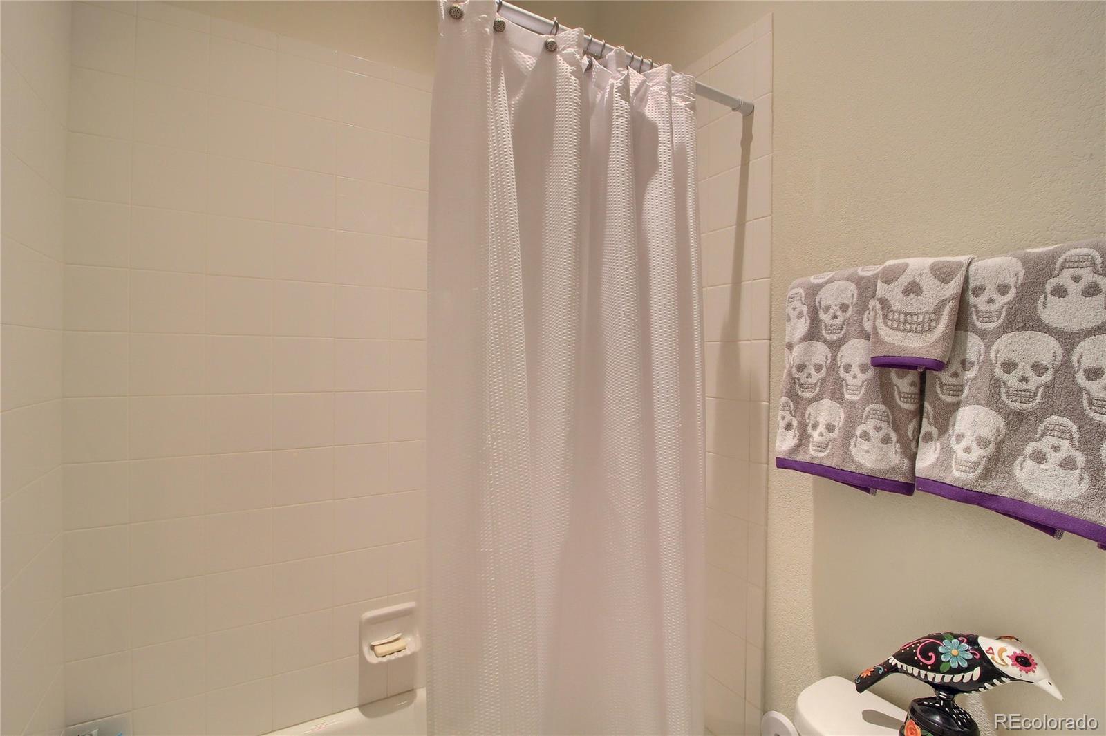 1335 South Chambers Road, Unit 101 Aurora, CO 80017 - Photo 31 of 40 a bathroom with a shower curtain and a shower curtain