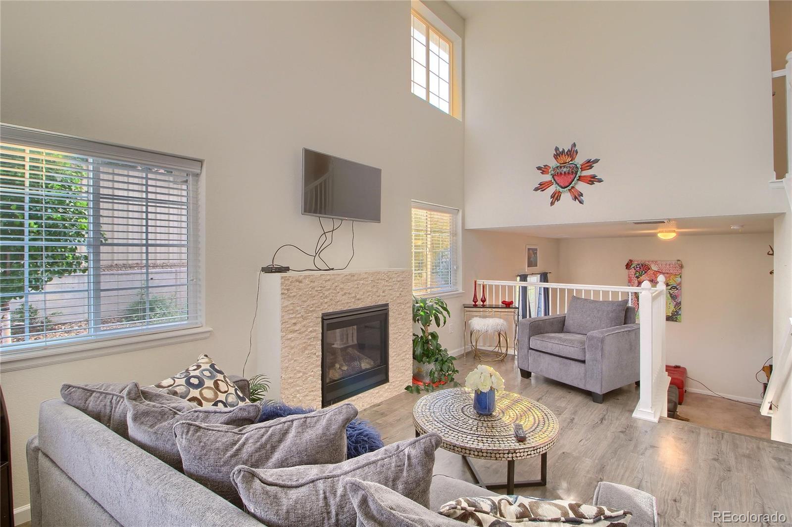1335 South Chambers Road, Unit 101 Aurora, CO 80017 - Photo 6 of 40 a living room with furniture and a fireplace