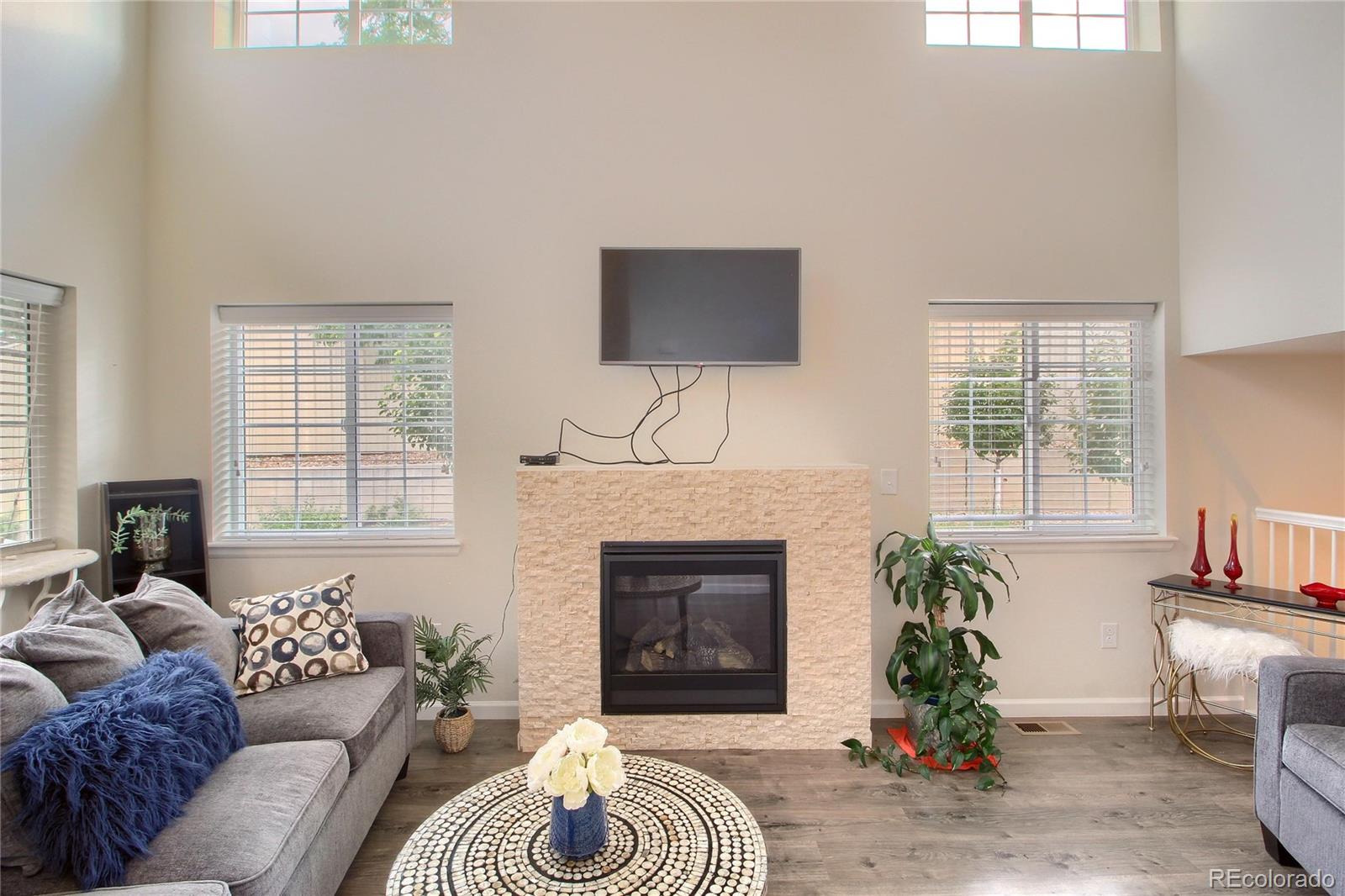 1335 South Chambers Road, Unit 101 Aurora, CO 80017 - Photo 7 of 40 a living room with furniture large window and a fireplace