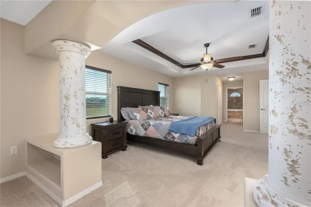 a spacious bedroom with a bed and a chandelier