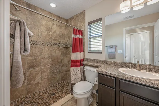 a bathroom with a granite countertop sink toilet and shower