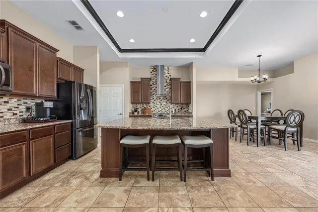 a large kitchen with stainless steel appliances granite countertop a stove and a sink