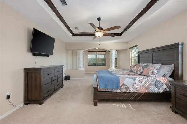 a spacious bedroom with a bed and a flat screen tv