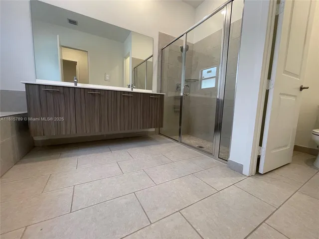a bathroom with a granite countertop sink and a toilet
