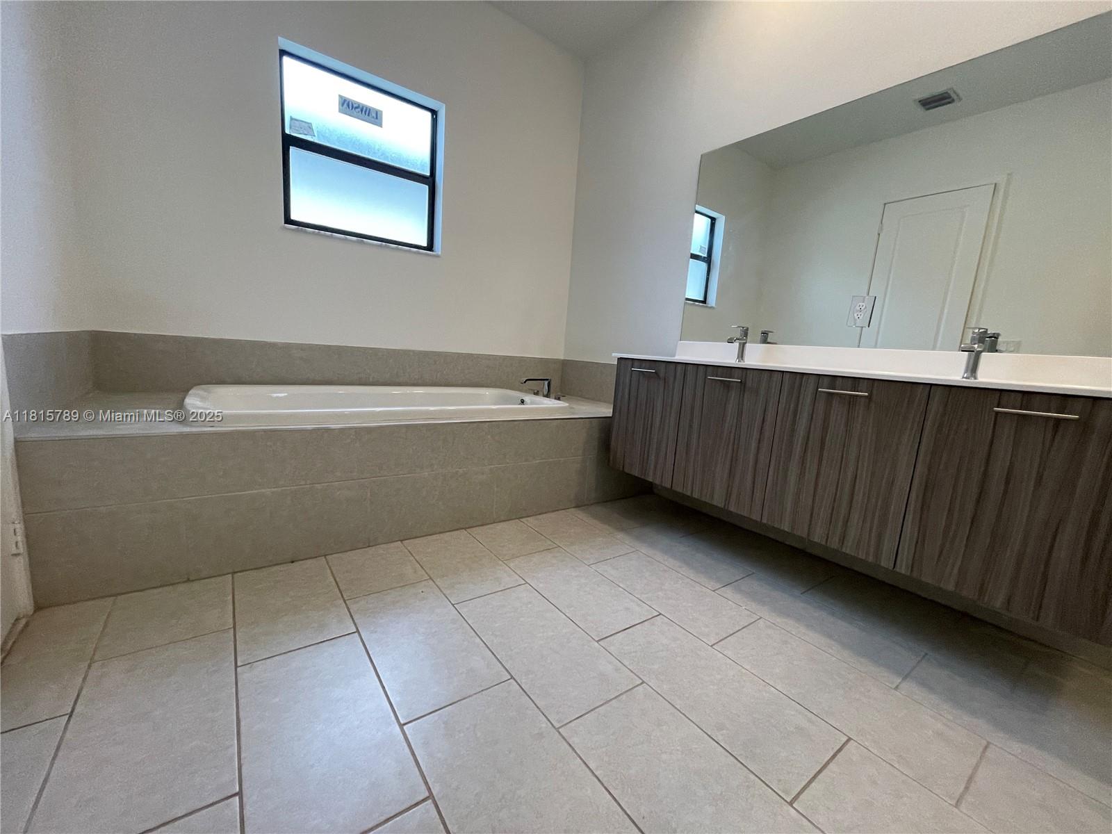4506 Southwest 174th Avenue, Unit 4506 Miramar, FL 33029 - Photo 14 of 80 a bathroom with a bathtub and mirror