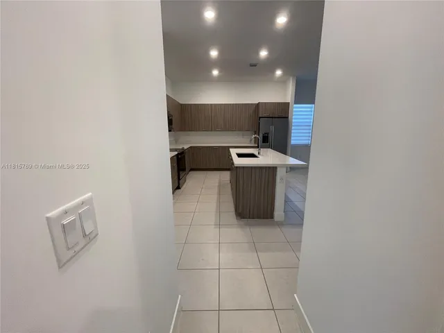 a kitchen with a sink a microwave a refrigerator and wooden floor