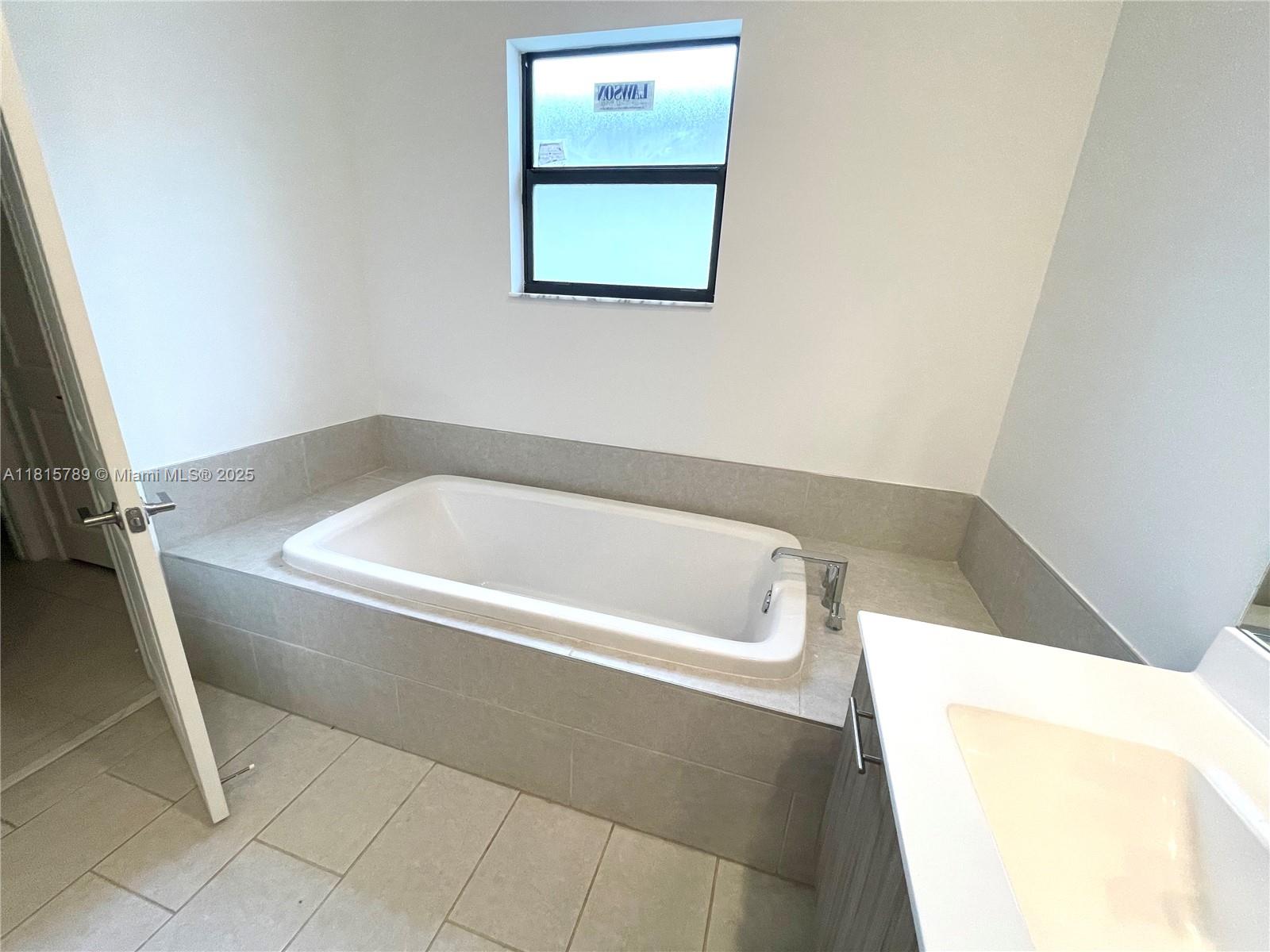 4506 Southwest 174th Avenue, Unit 4506 Miramar, FL 33029 - Photo 67 of 80 a bath tub sitting next to a white toilet and vanity
