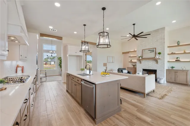 a large kitchen with stainless steel appliances kitchen island granite countertop a lot of counter space and wooden floors
