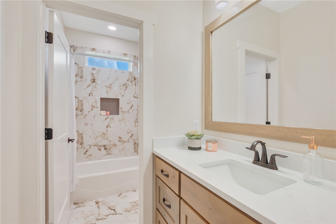 7888 Mathis Crk Drive Bryan, TX 77808 - Photo 31 of 41 Full bathroom featuring vanity, washtub / shower combination, and light marble finish flooring