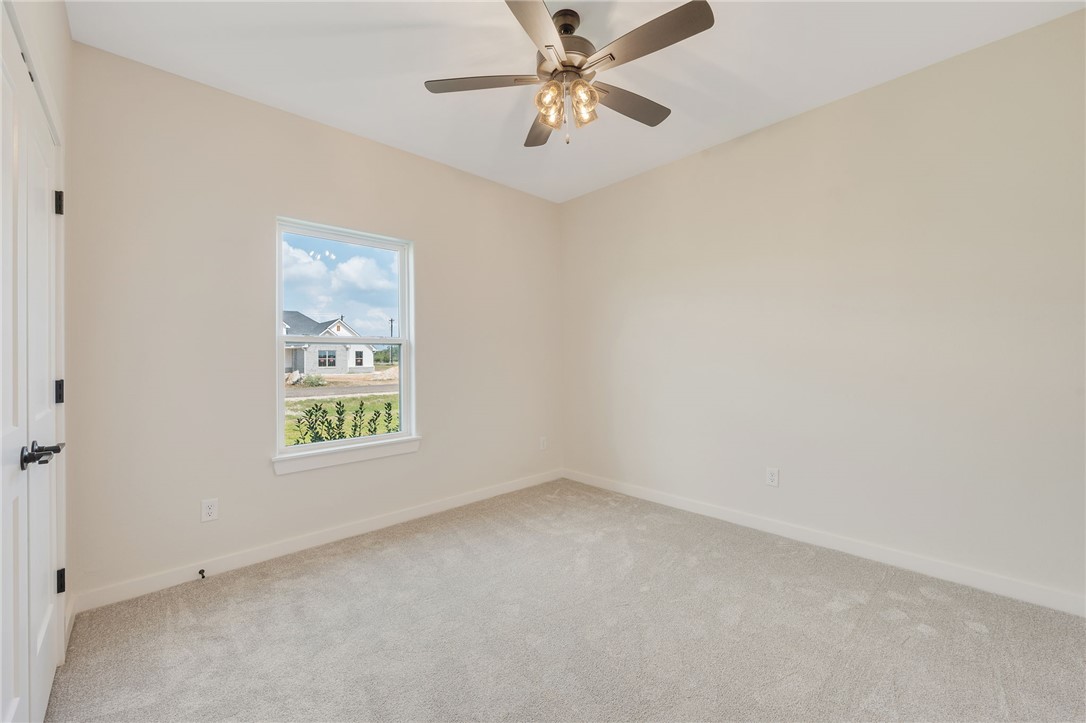 7888 Mathis Crk Drive Bryan, TX 77808 - Photo 32 of 41 Empty room with light carpet and a ceiling fan
