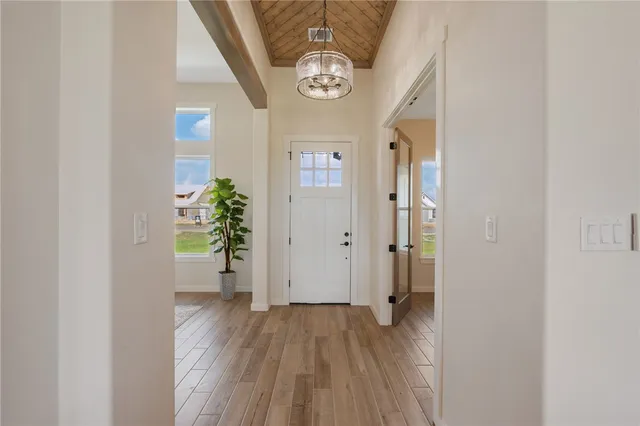 a view of a hallway with wooden floor and a potted plant