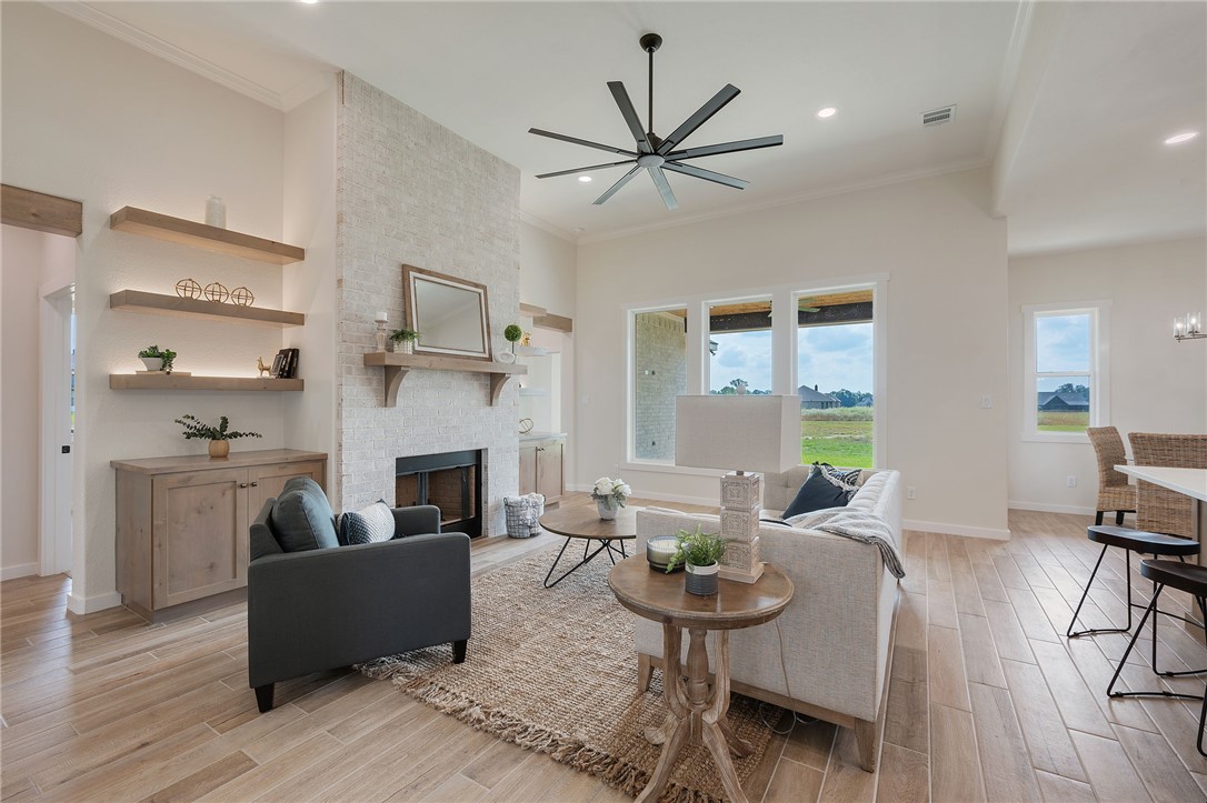 7888 Mathis Crk Drive Bryan, TX 77808 - Photo 7 of 41 Living area with crown molding, a fireplace, light wood-style floors, a ceiling fan, and recessed lighting