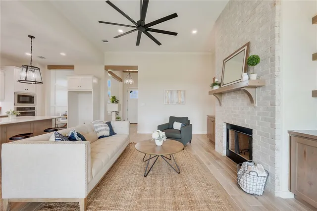 a living room with furniture a fireplace and a ceiling fan