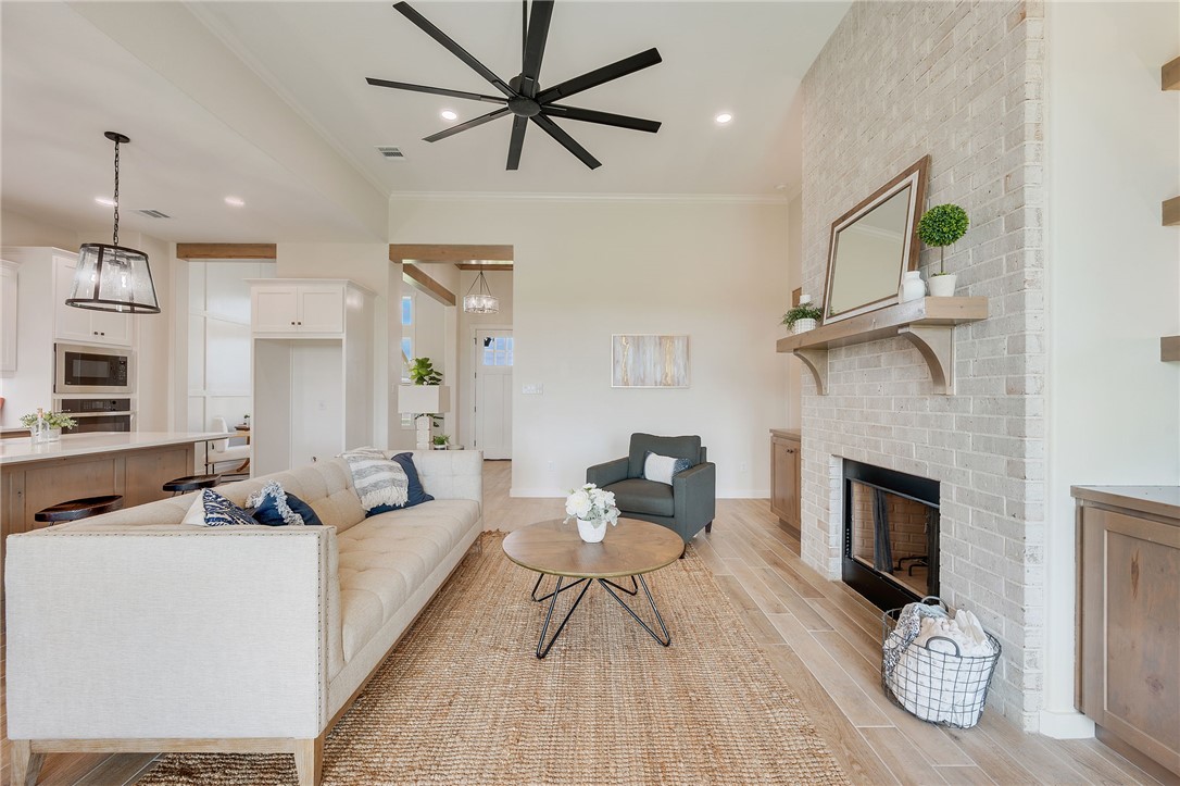 7888 Mathis Crk Drive Bryan, TX 77808 - Photo 10 of 41 Living area with recessed lighting, light wood-style flooring, a chandelier, a fireplace, and crown molding