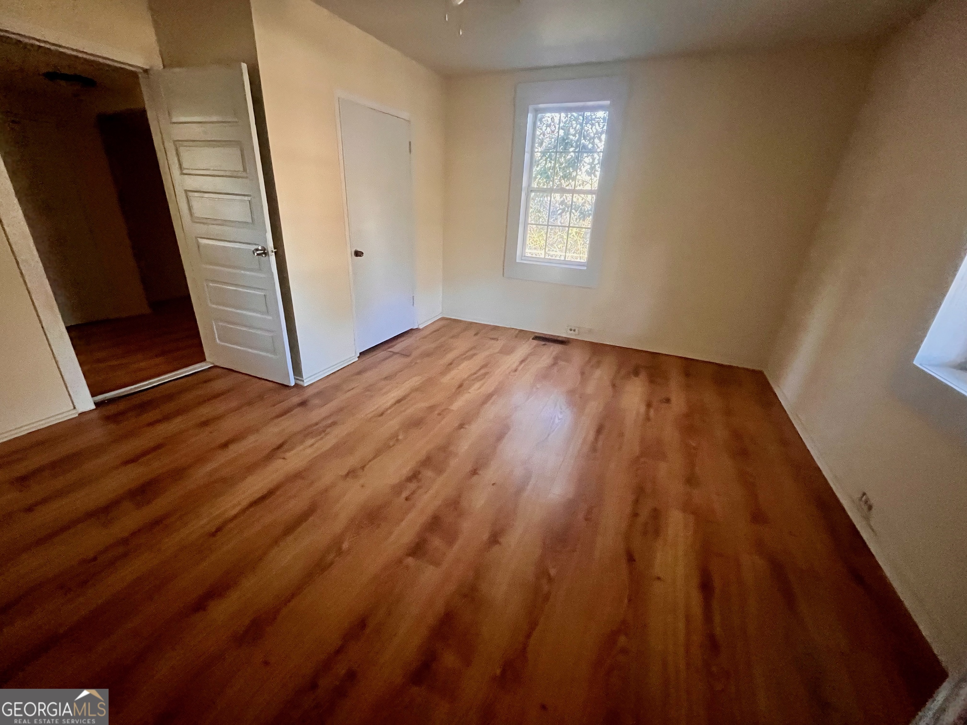 1202 Juniper Street LaGrange, GA 30240 - Photo 8 of 15 a view of an empty room with wooden floor and a window