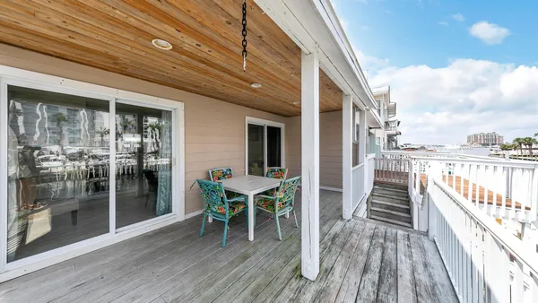 a view of a balcony dining table and chairs with wooden floor