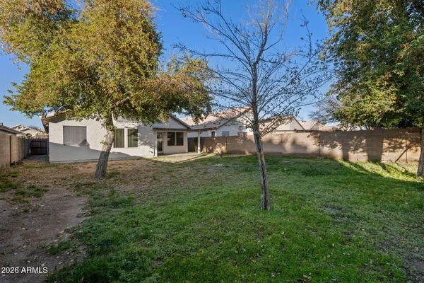 a view of a house with backyard and a tree