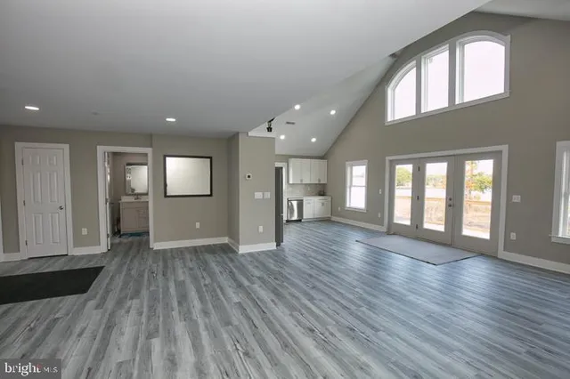 an empty room with wooden floor and a fireplace