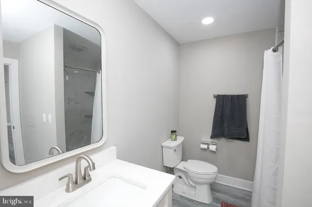 a bathroom with a sink toilet and mirror