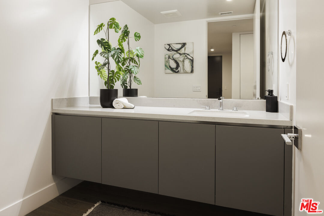 411 South Hamel Road, Unit 106 Los Angeles, CA 90048 - Photo 12 of 17 a bathroom with a granite countertop sink a mirror and vanity