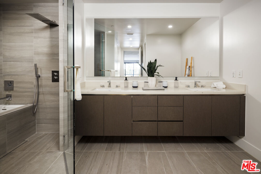 411 South Hamel Road, Unit 106 Los Angeles, CA 90048 - Photo 7 of 17 a bathroom with a double vanity sink a mirror and a bathtub