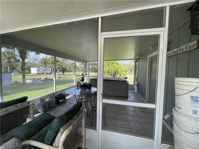 a living room with patio furniture and a floor to ceiling window