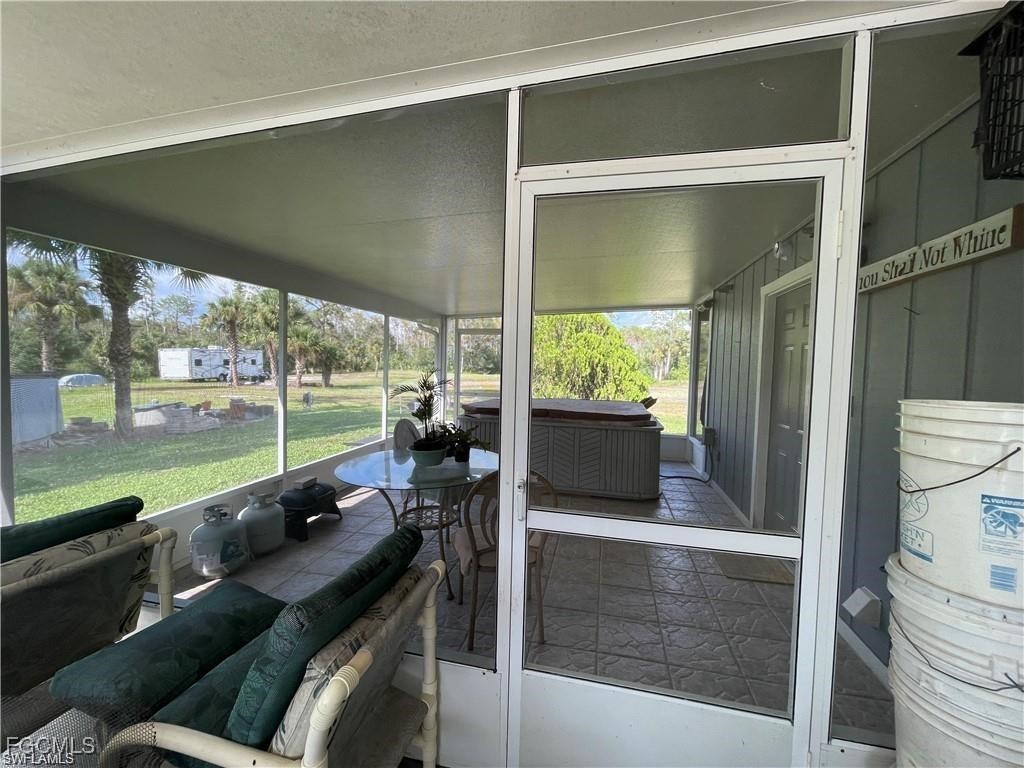 19790 Burgundy Farms Road Estero, FL 33928 - Photo 6 of 12 a living room with patio furniture and a floor to ceiling window