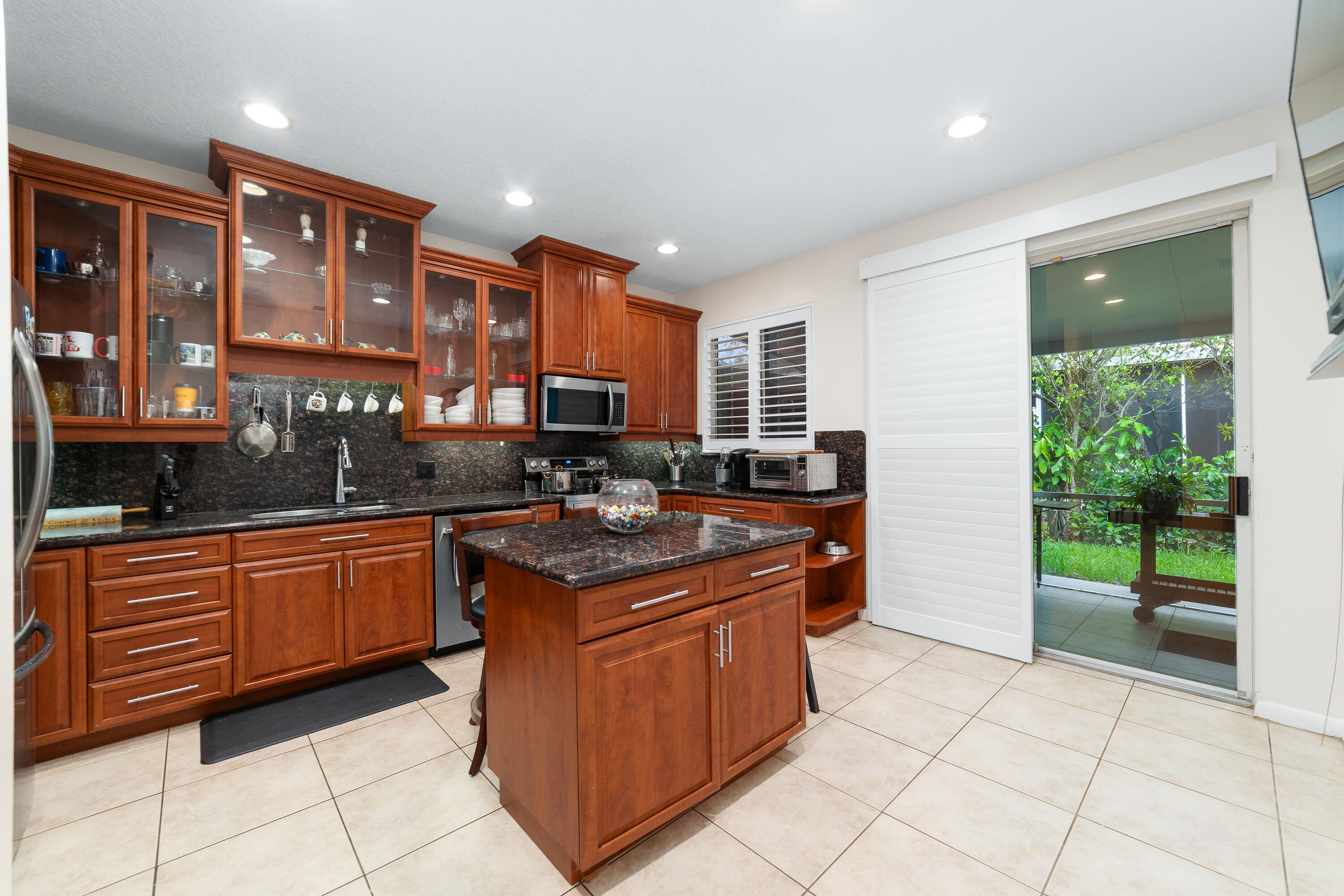 a kitchen with stainless steel appliances granite countertop a stove a sink and a microwave
