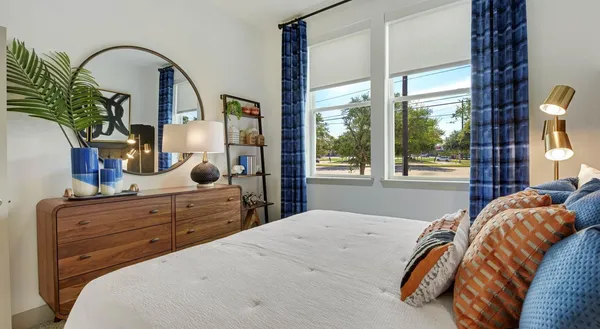 a bedroom with a bed and a large window