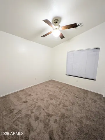 an empty room with a window and a fan
