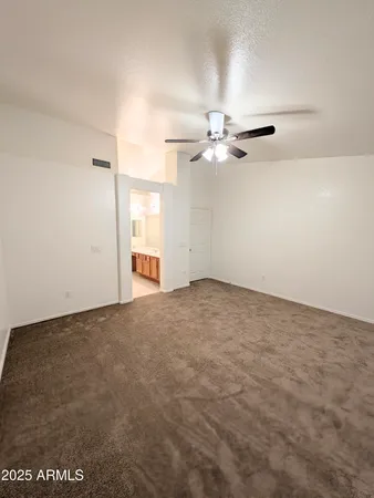 an empty room with a ceiling fan and a window
