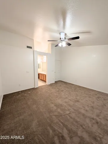 an empty room with a ceiling fan and a window