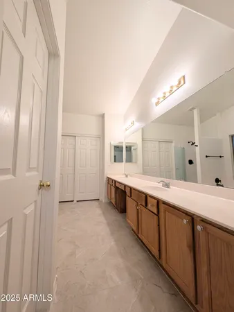 a large bathroom with a double vanity sink a large mirror and a bathtub