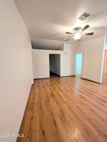 a view of empty room with wooden floor