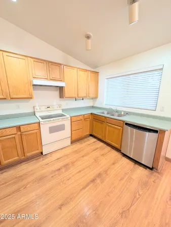 a large kitchen with wooden cabinets and a sink