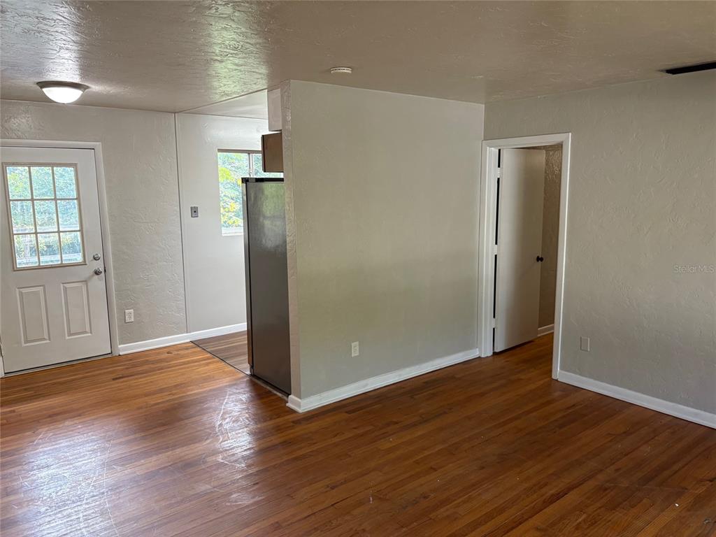 401 Northwest 36th Street Gainesville, FL 32607 - Photo 2 of 13 an empty room with wooden floor and windows