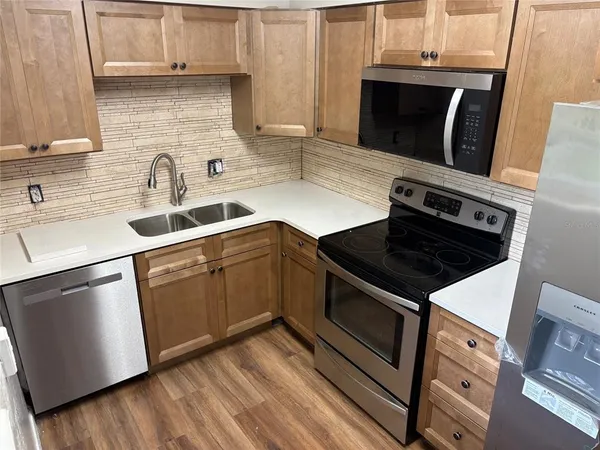 a kitchen with granite countertop a stove sink and microwave