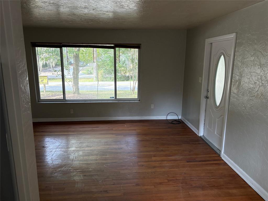 401 Northwest 36th Street Gainesville, FL 32607 - Photo 5 of 13 a view of empty room with wooden floor and fan