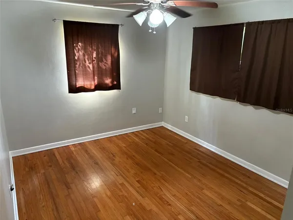 a view of an empty room with wooden floor