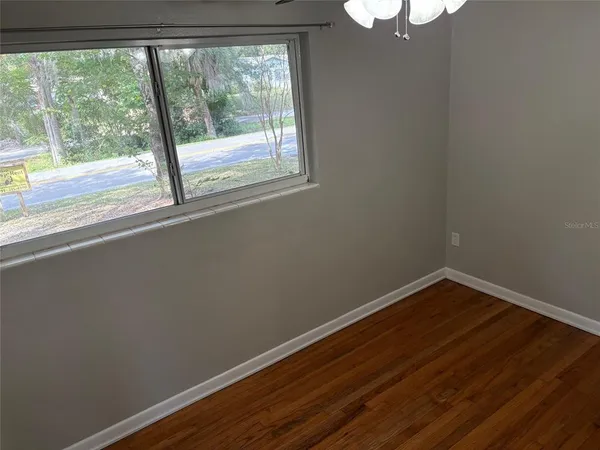 a view of a small space with wooden floor and a window