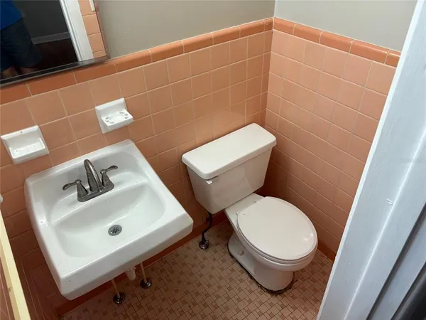 a white toilet sitting next to a bathroom sink