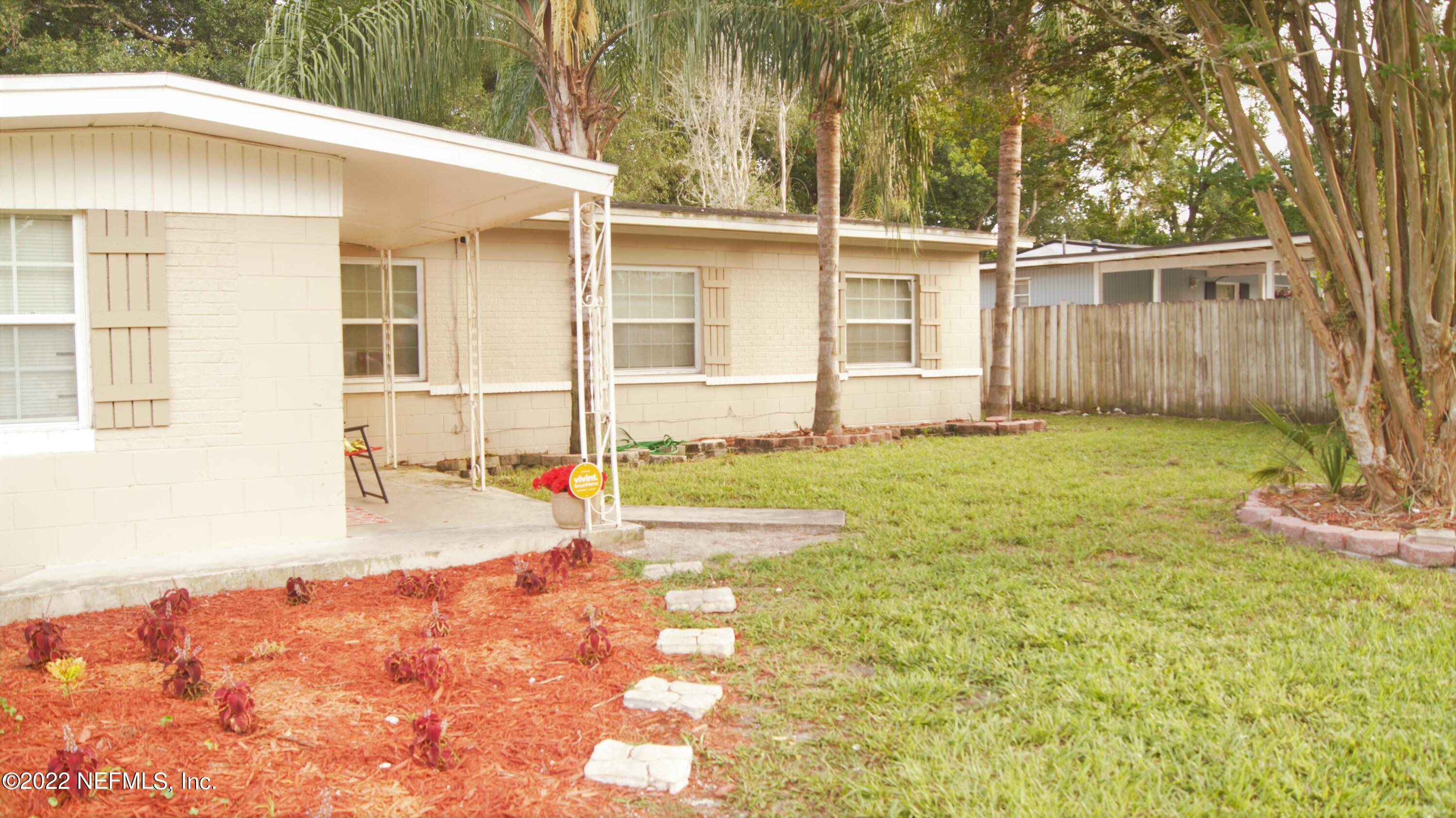 7506 Strato Road Jacksonville, FL 32210 - Photo 7 of 10 a view of a backyard with a large tree