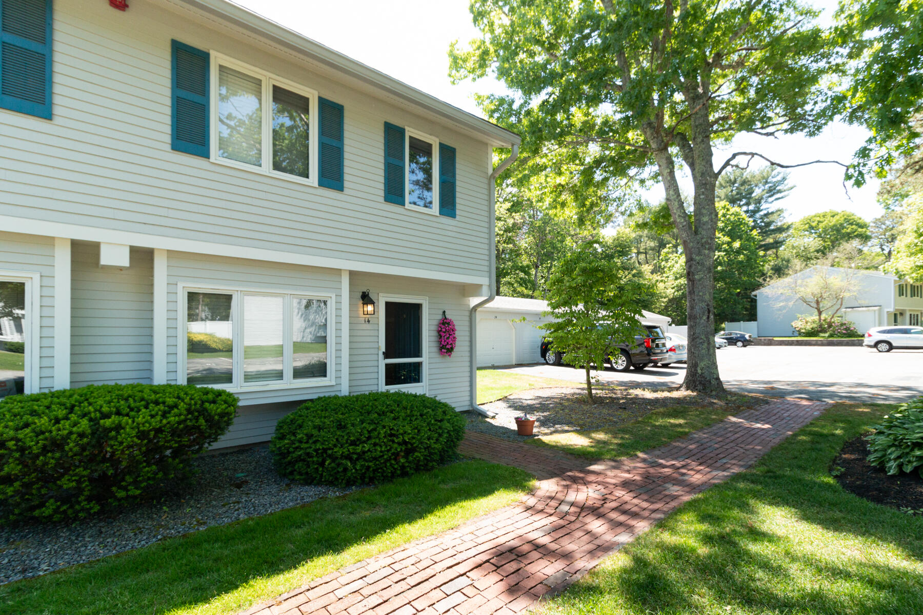 174 Lowell Road, Unit U14 Mashpee, MA 02649 - Photo 3 of 31 a front view of a house with a garden and trees