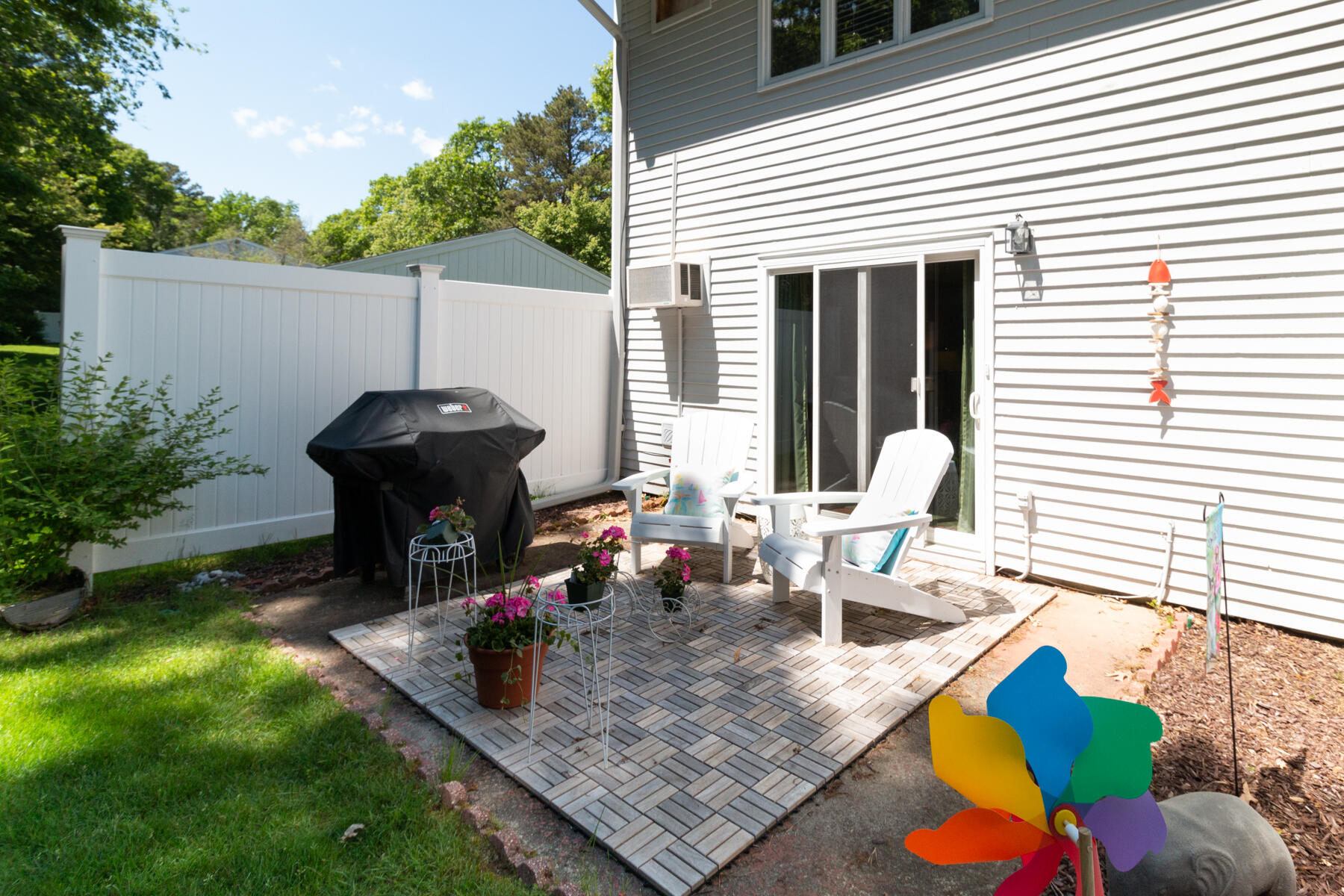 174 Lowell Road, Unit U14 Mashpee, MA 02649 - Photo 5 of 31 a view of a patio with table and chairs potted plants with wooden floor