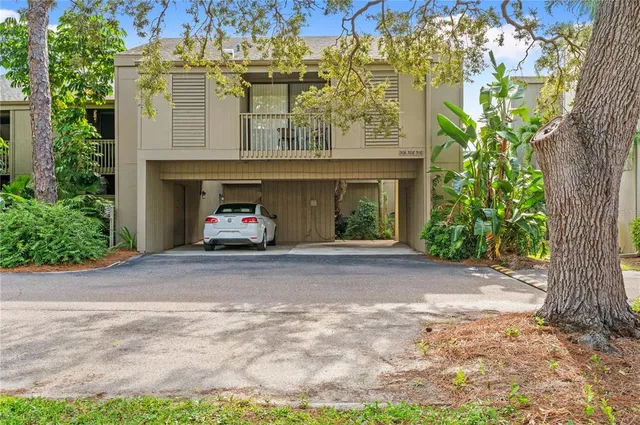 a car parked in front of yellow house with a yard