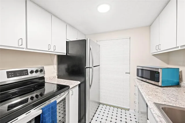 a kitchen with granite countertop a stove microwave and refrigerator
