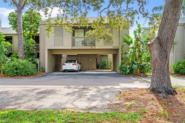 a view of a car parked in front of a house with a tree