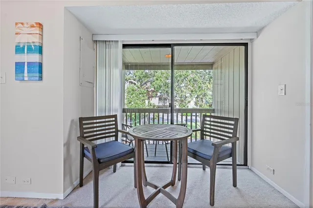 a view of a room with a wooden table and chairs