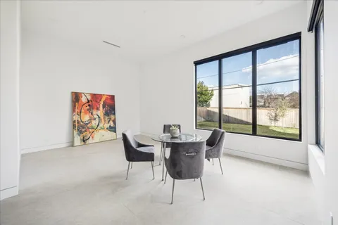 a dining room with furniture and a large window